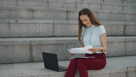 surprised businesswoman checking information from documents on laptop computer
