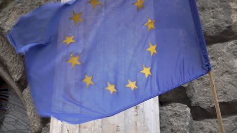 Schwenkende-Flagge-Der-Europäischen-Union-Vor-Steinmauer-1