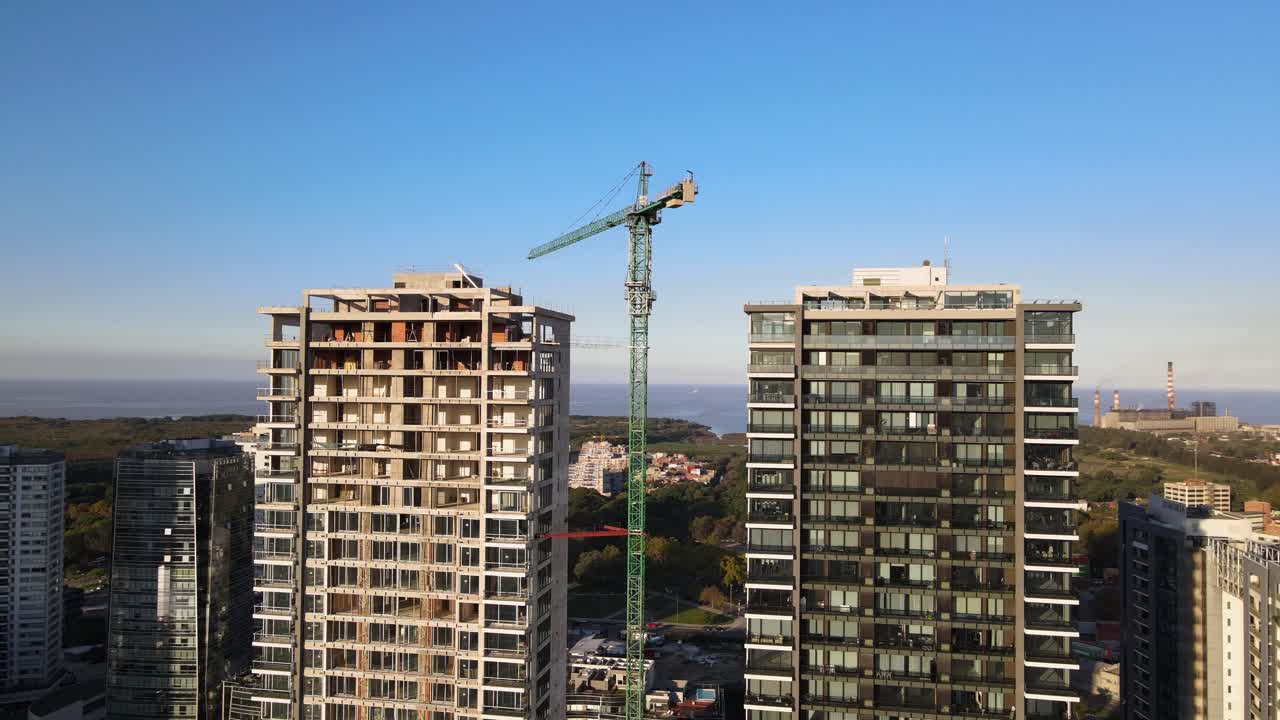 toma de órbita aérea de una grúa entre dos rascacielos en construcción en la ciudad de buenos aires
