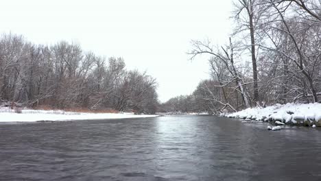 low aerial view passing over the boise river in idaho on a cold winter day