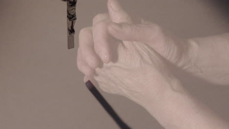 Animation of hands of caucasian woman praying over cross