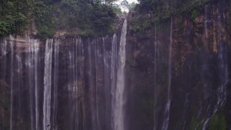 reveal shot of tumpak sewu thousand waterfalls in hidden canyon, aerial