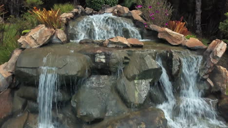 Aerial-Shot-of-Waterfall-in-Swimming-Pool-of-Resort-in-Jungle-of-Brazil