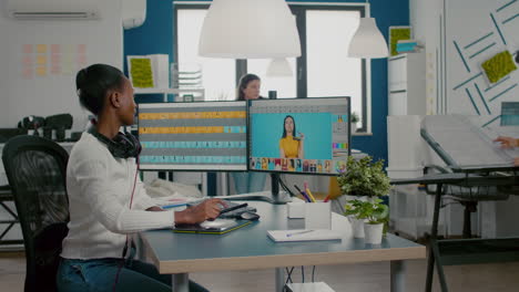 black retoucher woman analysing images on computer with two monitors