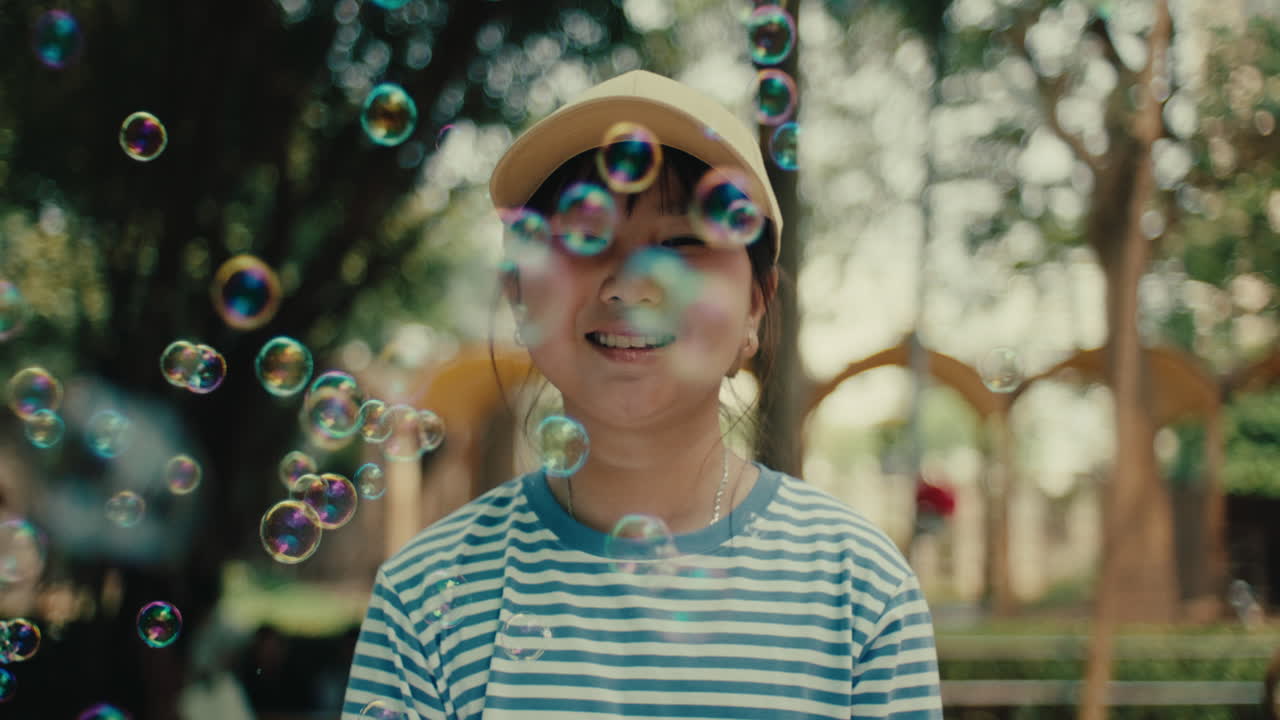Smiling Girl Playing With Bubbles in a Park