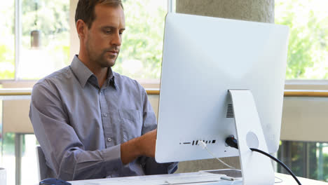 male executive talking on mobile phone while working at desk 4k