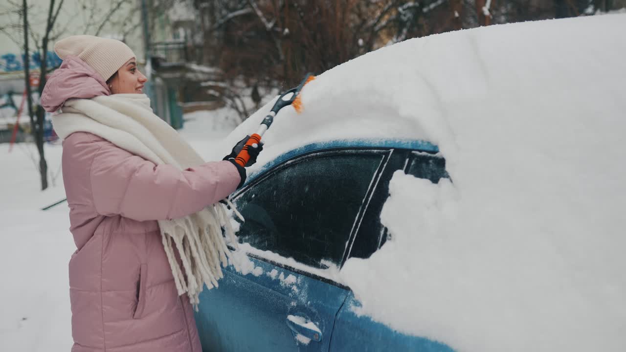 mujer quitando la nieve de un coche en invierno