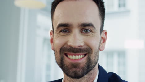 primer plano del joven apuesto sonriendo y mirando a la cámara