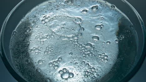 fizzy drink bubbling inside container closeup. sparkling aqua glass macro view