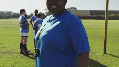 female rugby coach and team on a rugby pitch