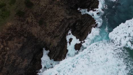 Vista-Aérea-De-Las-Olas-Del-Océano-Rompiendo-En-El-Cabo-Rocoso-De-Byron-Bay,-Nueva-Gales-Del-Sur,-Australia