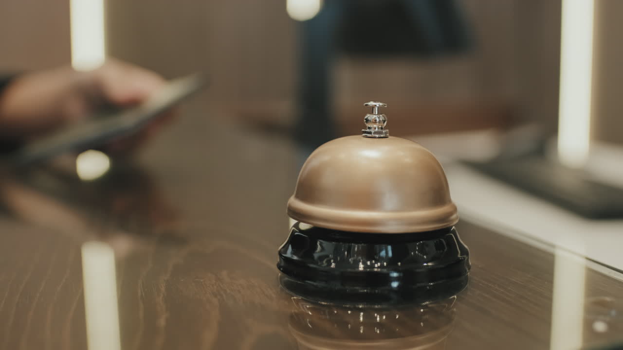 Hand Ringing Service Bell on Hotel Reception Desk
