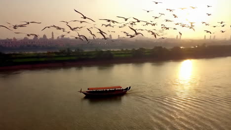 sunrise over river with birds and boat