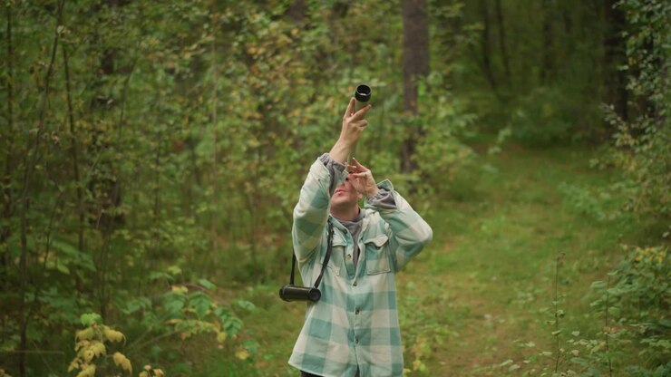 caucasian woodsman signaling with handmade horn on forest path, blowing rustic wooden horn, echoing sound across canopy, plaid jacket and beanie, backpack at side, nostalgic rural mood, solitude