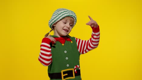 Kid-girl-in-Christmas-elf-Santa-helper-costume-dancing,-fooling-around.-New-Year-holiday-celebration