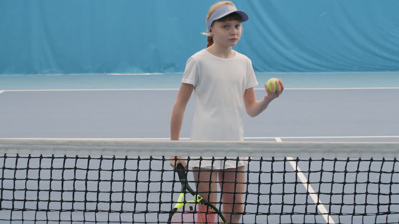 Little Girl Hitting Tennis Ball On Court