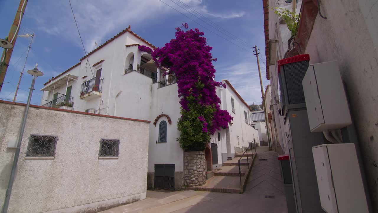 Charming house in Anacapri adorned with big purple flowers hanging from the outdoor