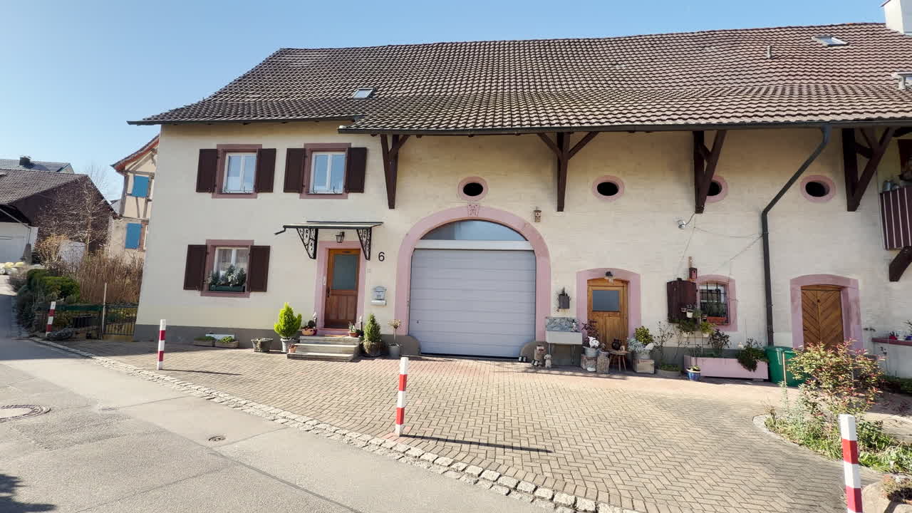 Una vecchia casa colonica beige a Tumringen con un grande portone del fienile a Lörrach, Germania