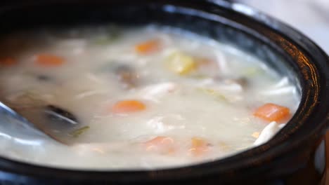 creamy soup with vegetables and rice, served in a bowl with a spoon