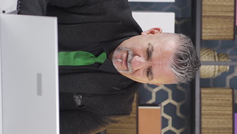 video vertical del hombre de negocios triste viendo su fracaso en la computadora portátil.
