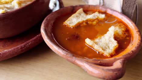 Traditional Mexican red pozole garnished with crunchy chicharron