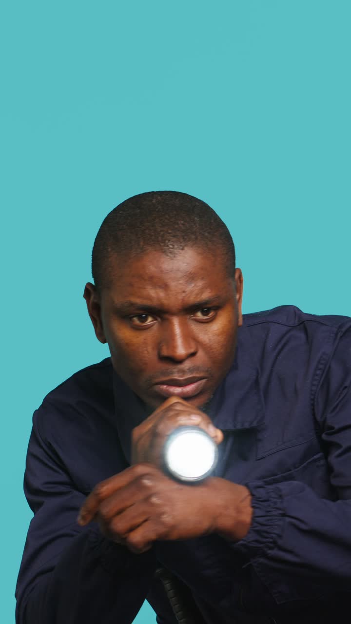 African American Man Searching with Flashlight on Blue Background