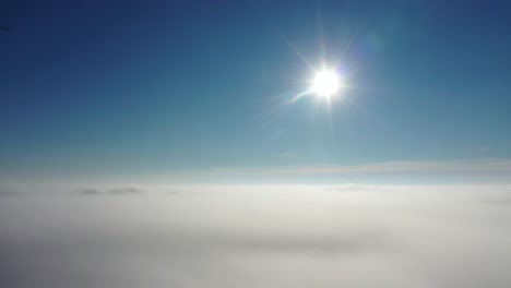 above the clouds with a bright sun