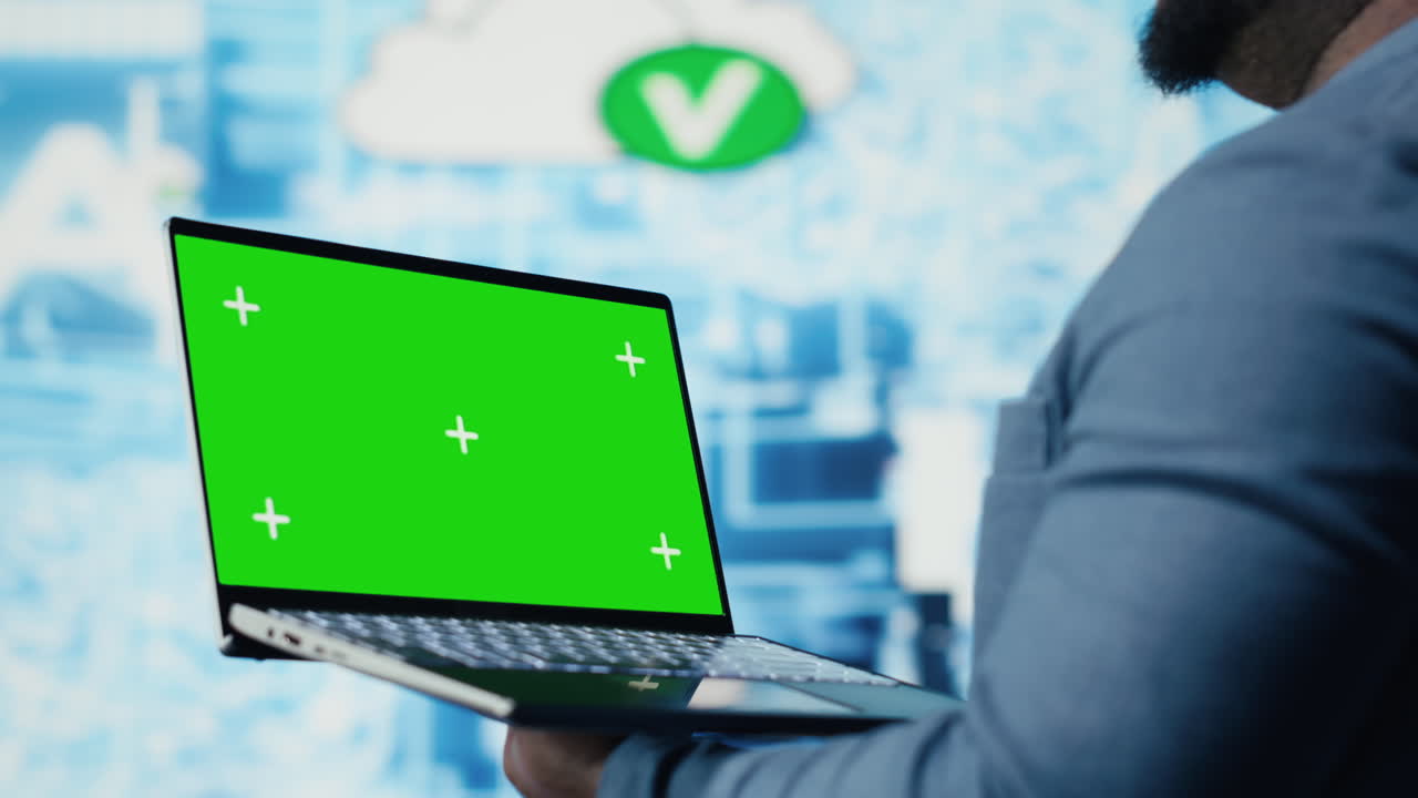 Black male engineer showing laptop with chroma key display