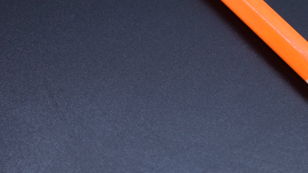 Orange colored pencil crayon rotating macro shot, zoom close up video