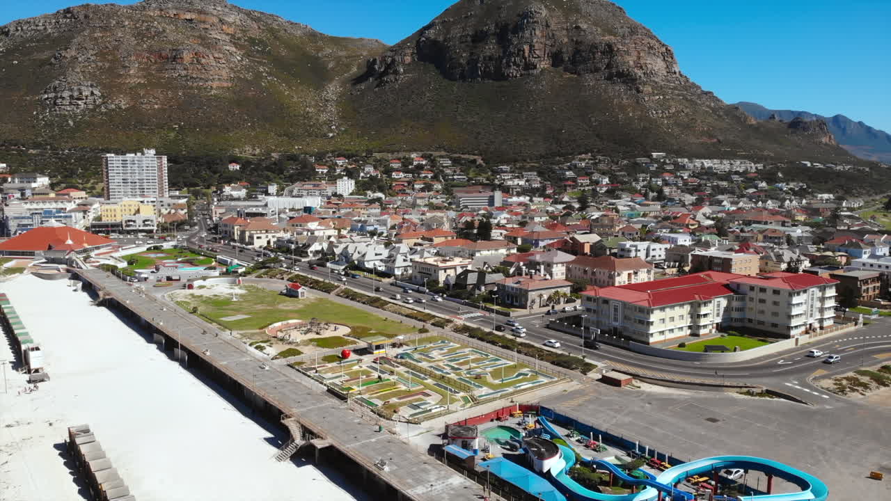 Aerial View of Coastal Town with Mountain Backdrop
