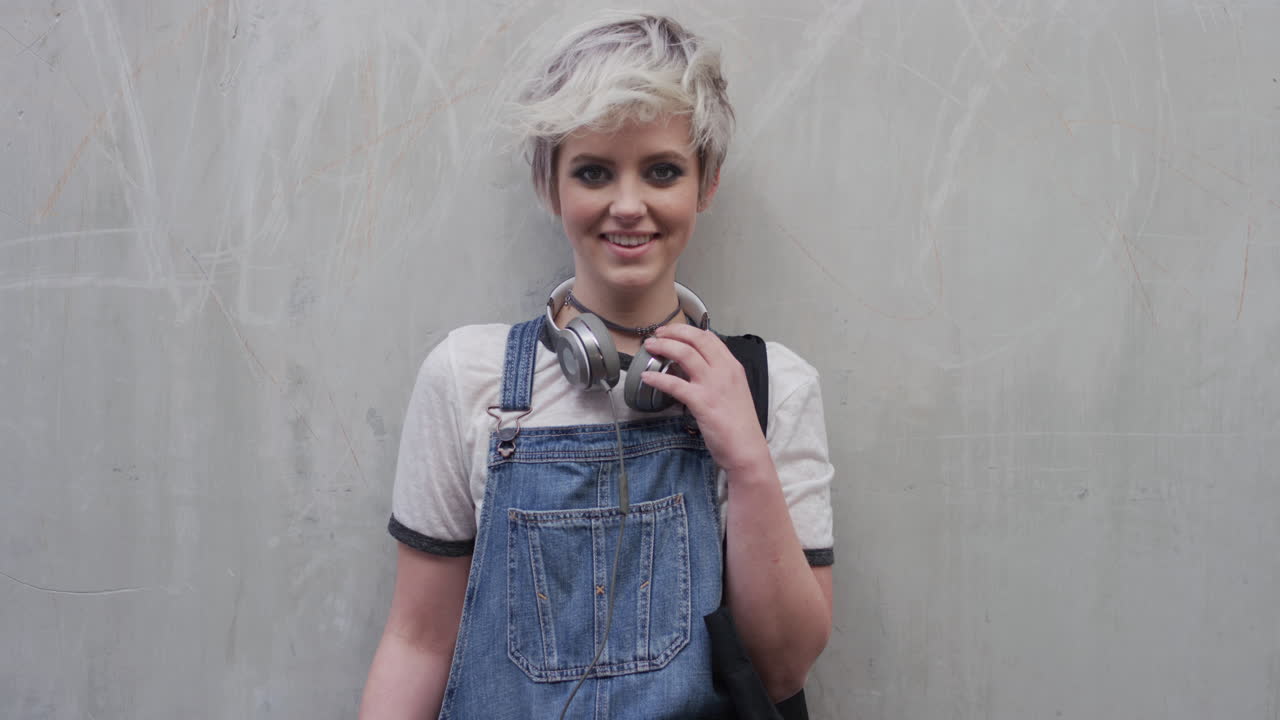 초상화: 자신감 넘치는 젊은 여성 학생, 웃는 행복, 편안한 라이프 스타일을 즐기고, 콘크리트 벽 배경에 있는 아름다운 트렌디 소녀, 느린 동영상