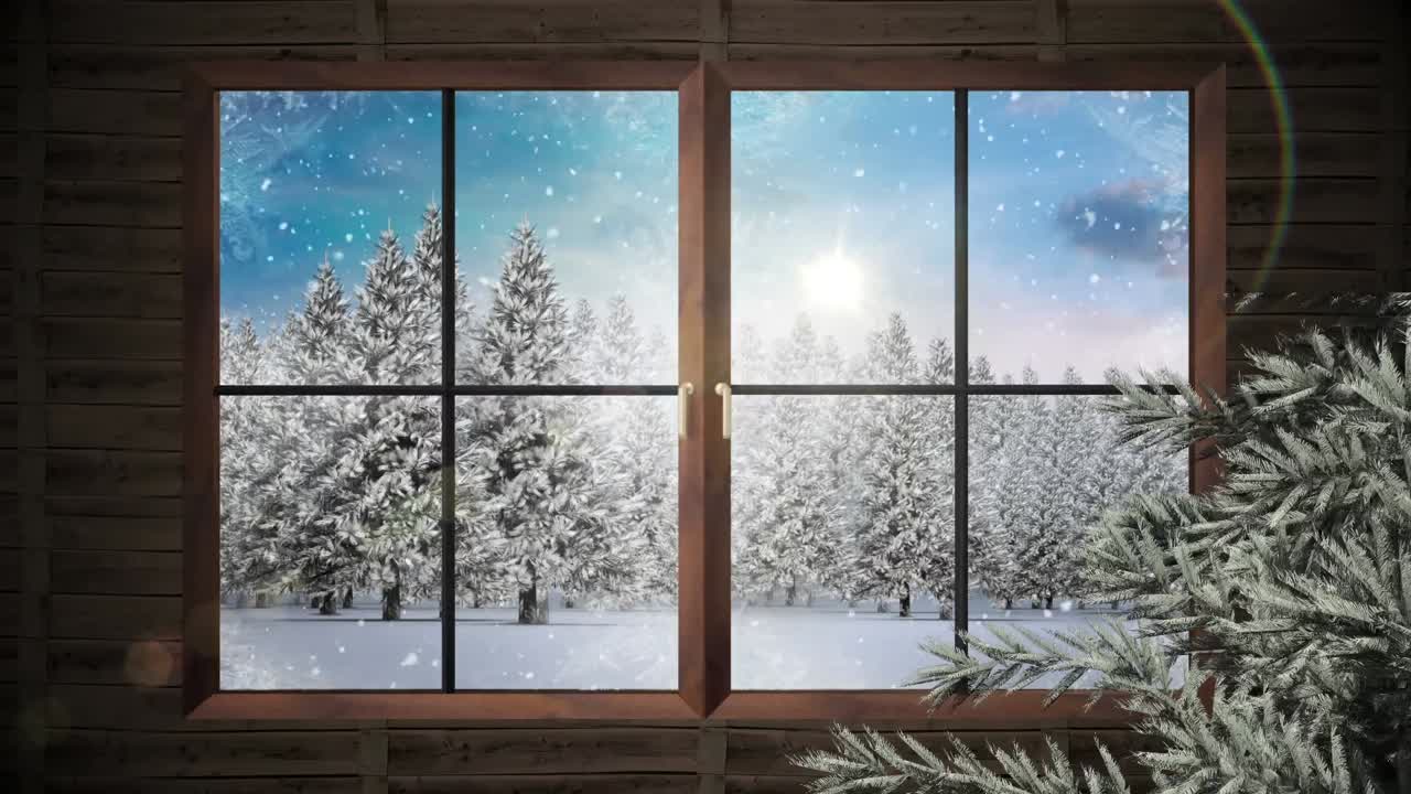 Wooden window frame and tree branch against snow falling over multiple trees on winter landscape