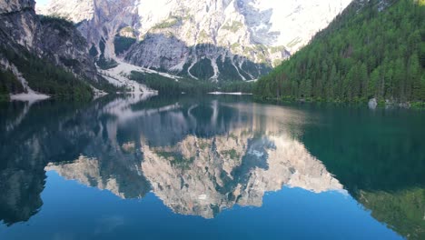 low aerial flying over pragser wildsee, seekofel reflecting on water surface