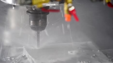 la máquina de perforación cnc perfora con precisión en el metal con refrigerante de agua
