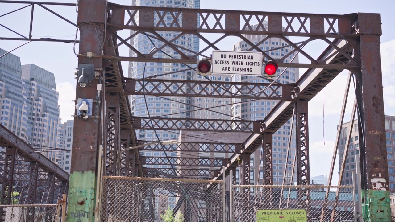 Cinematic dolly in toward an abandoned bridge in Boston, Massachusetts. Weathered steel structure and industrial details create a dramatic urban scene with historic character on a su