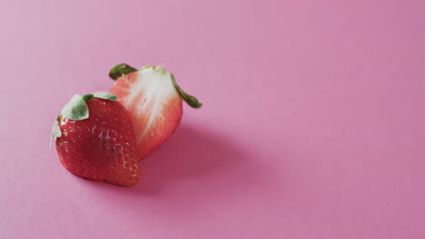 video de fresa cortada por la mitad con espacio de copia sobre fondo rosa
