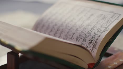 Close-Up-Of-Open-Copy-Of-The-Quran-On-Stand-At-Home-5