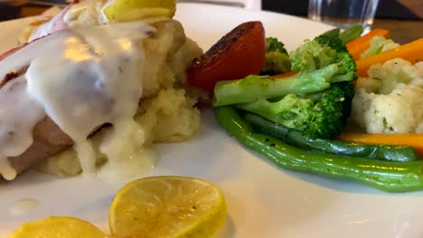 a plate of grilled fish saltimboca and steamed vegetables at a local restaurant