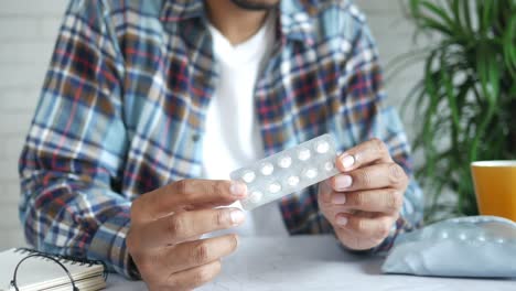 man holding a blister pack of pills