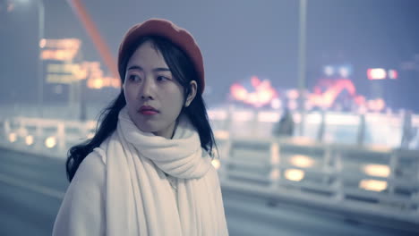 retrato de una mujer feliz, elegante y segura caminando por el puente de la ciudad por la noche