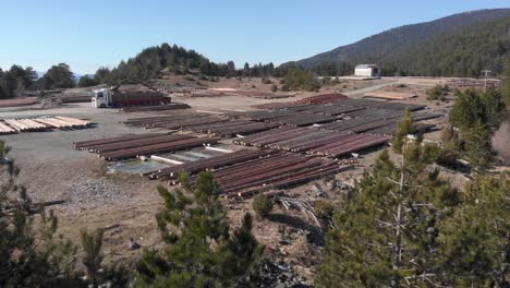 aerial view log grabber among timber loading truck lumberyard day