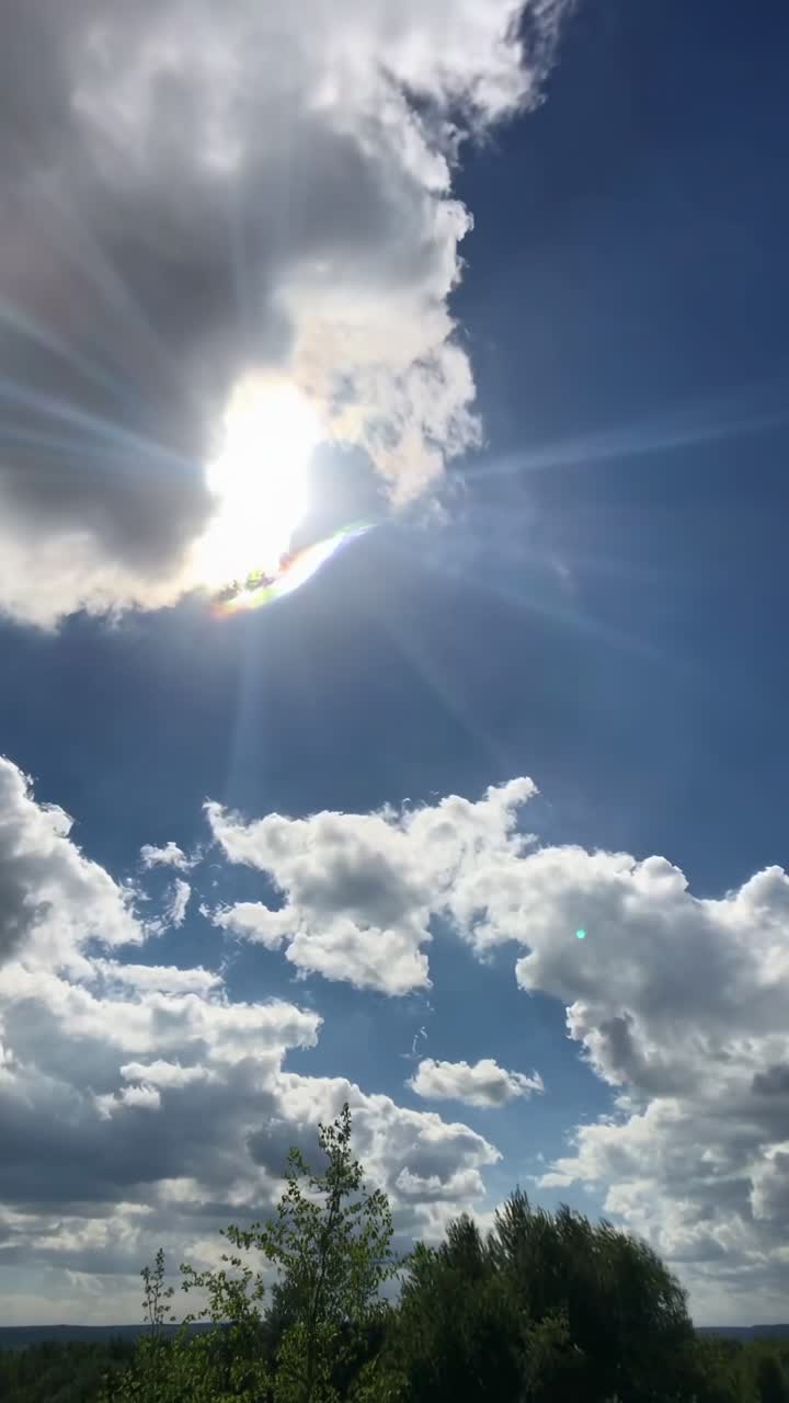 Un video sereno di un sole splendente che fa capolino tra le nuvole, ripreso da un'angolazione bassa