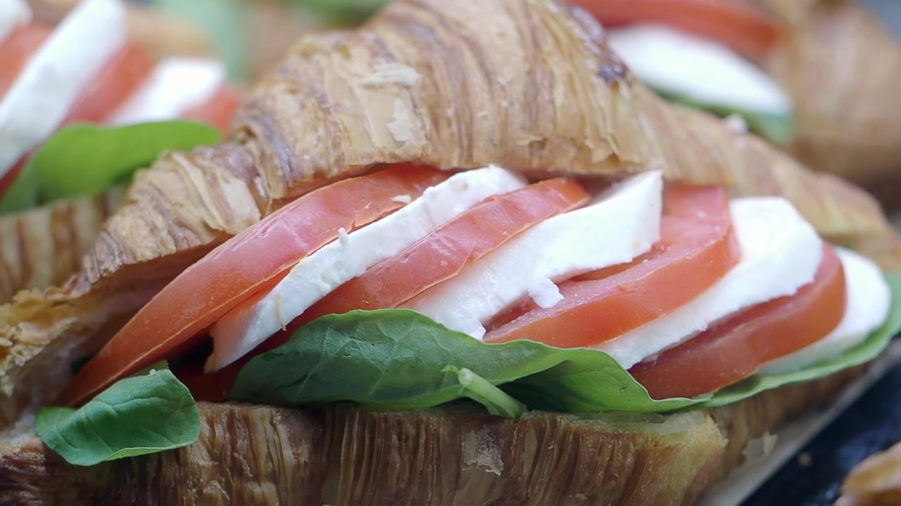 Sandwich di croissant fresco con pomodoro a fette e mozzarella