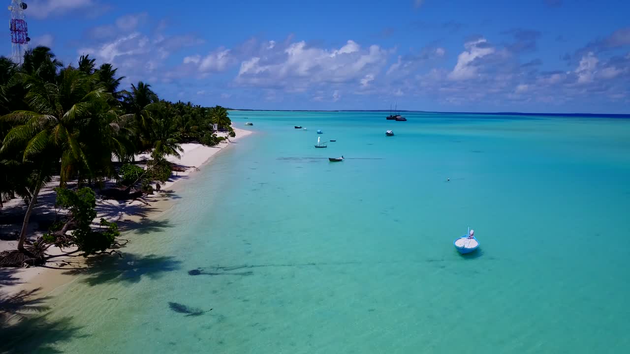 imágenes aéreas a lo largo de la costa de una isla tropical con palmeras en las playas de arena blanca y pequeñas embarcaciones ancladas en la costa