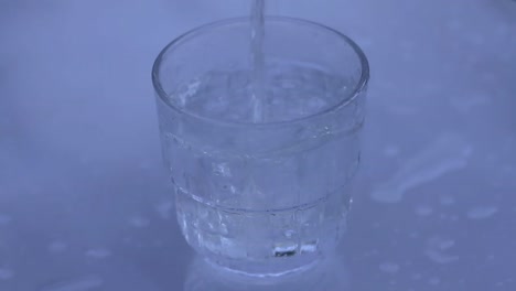 Ein-Glas-Wasser-Auf-Einem-Tisch-Mit-Fließendem-Wasser-Einschenken,-Keine-Stockvideos-Von-Menschen