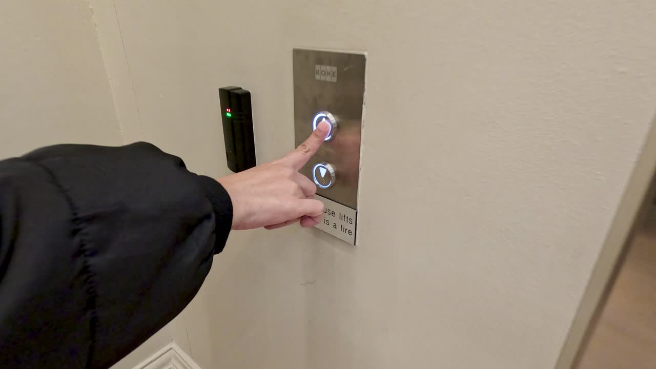 Person interacts with elevator button panel