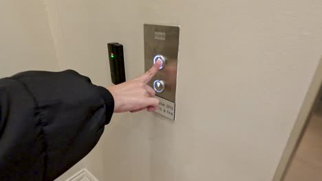 person interacts with elevator button panel