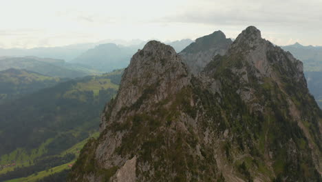 Dolly-back-drone-shot-starting-on-a-climber-hanging-in-a-mountain-wall-in-Switzerland