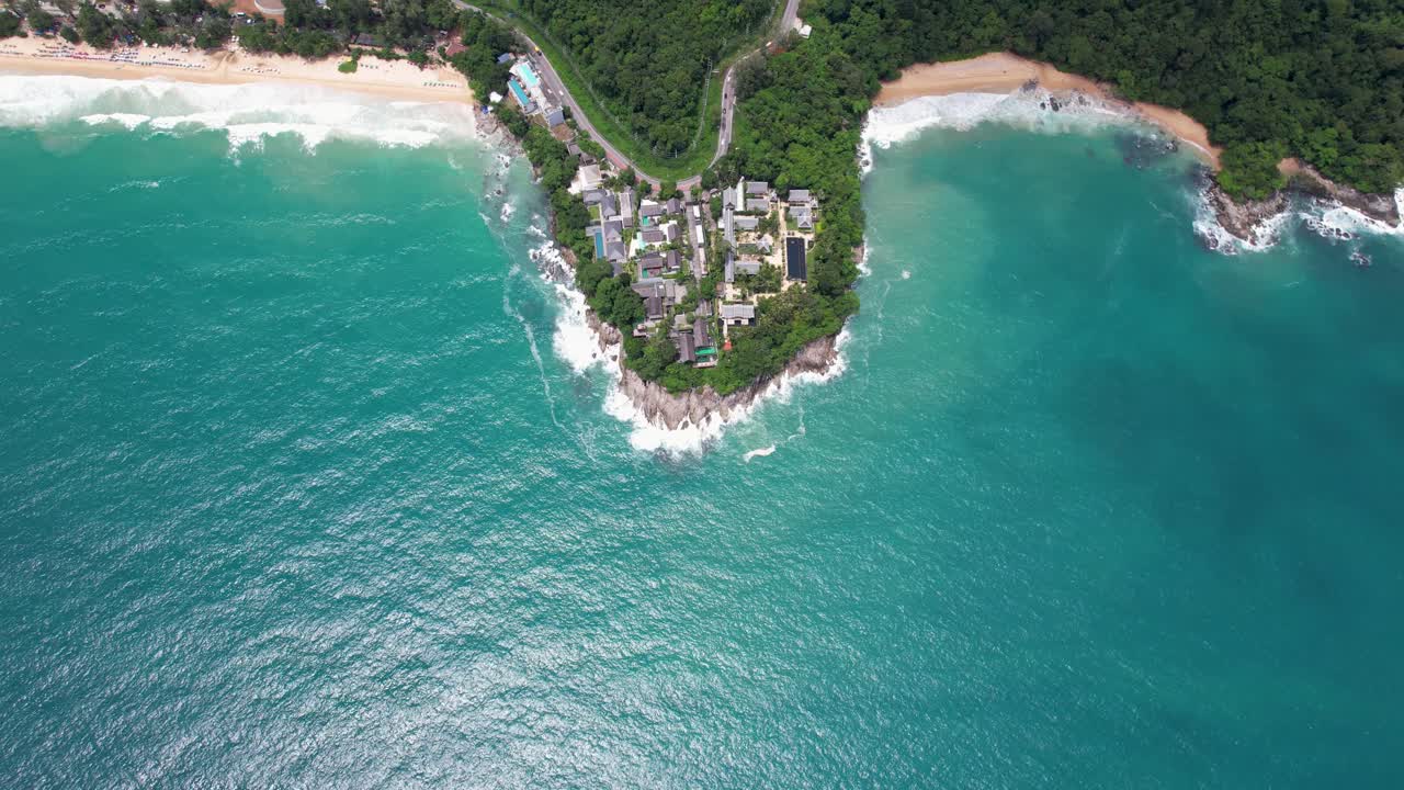 Aerial View of Tropical Coastline with Lush Greenery and Rocky Peninsula Surrounded by Turquoise Ocean Waves