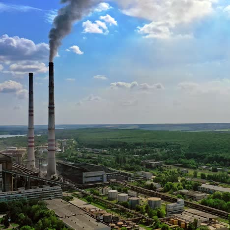 industrial territory among nature. factory with pipes against blue sky. dark smoke goes from industrial pipe. panoramic view of manufacturing on nature background.